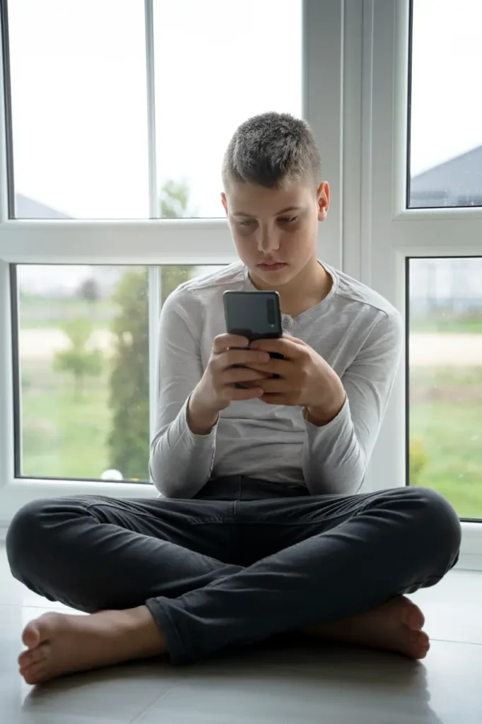 Young teenage boy betting on mobile-Parents Standing Together